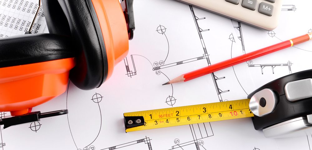 home extension plans with a calculator and protective ear gear