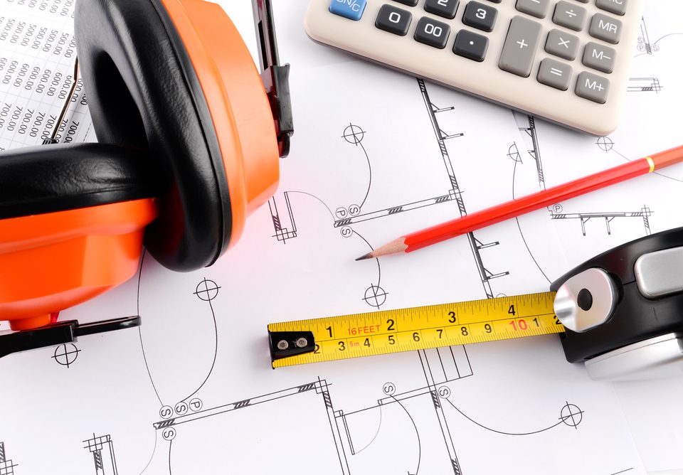 home extension plans with a calculator and protective ear gear